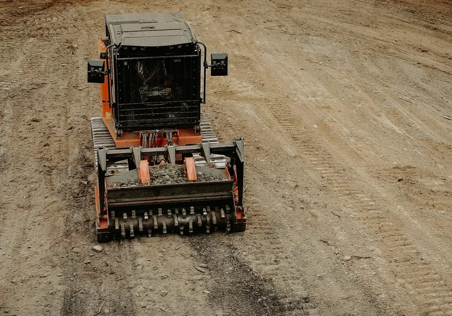 Elevated front view of a tracked forestry mulcher on smooth graded dirt